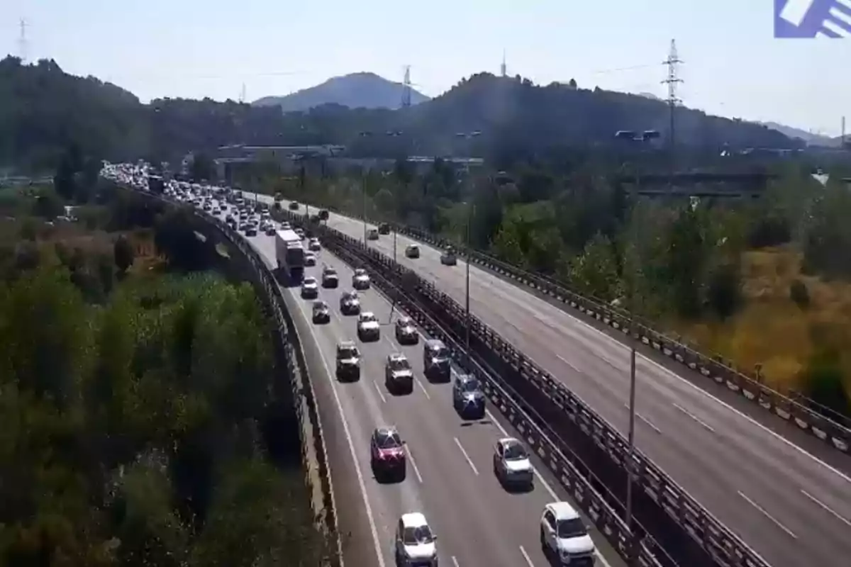 Autopista amb trànsit dens en un sentit i turons al fons