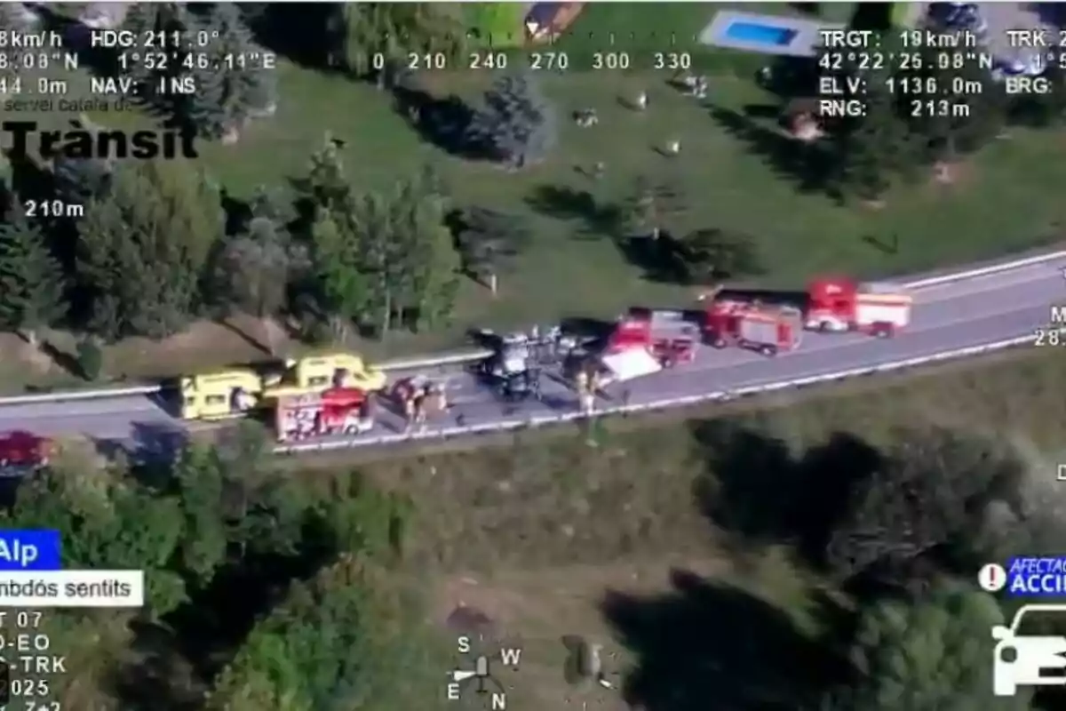 Vista aèria d’un accident de trànsit en una carretera envoltada de vegetació amb presència de diversos vehicles d’emergència com ambulàncies i camions de bombers