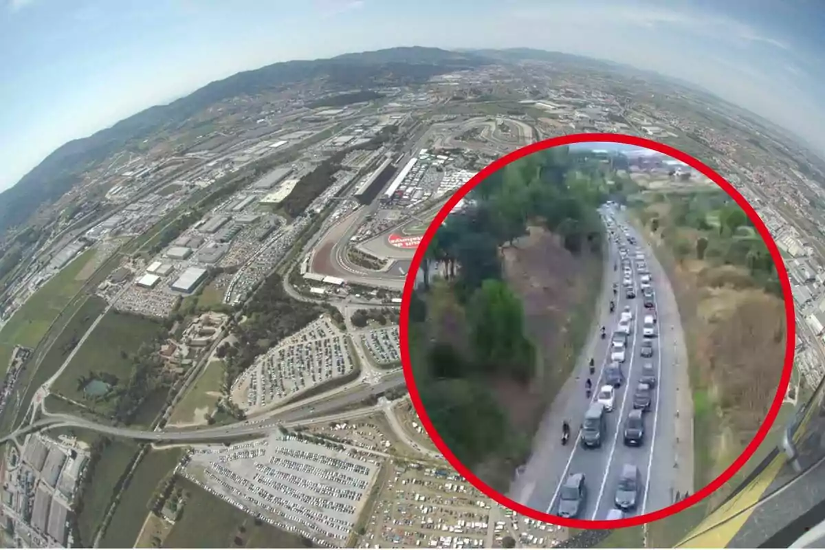 Vista aérea de un circuito de carreras con estacionamientos llenos y un recuadro que muestra una carretera con tráfico denso rodeada de vegetación.