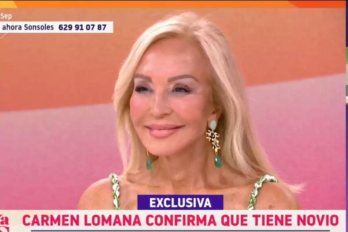 Carmen Lomana rubia sonriente con pendientes verdes sentada en un plató de televisión con un rótulo que anuncia una exclusiva sobre su vida sentimental Carmen Lomana rubia sonriente con pendientes verdes sentada en un plató de televisión con un rótulo que anuncia una exclusiva sobre su vida sentimental