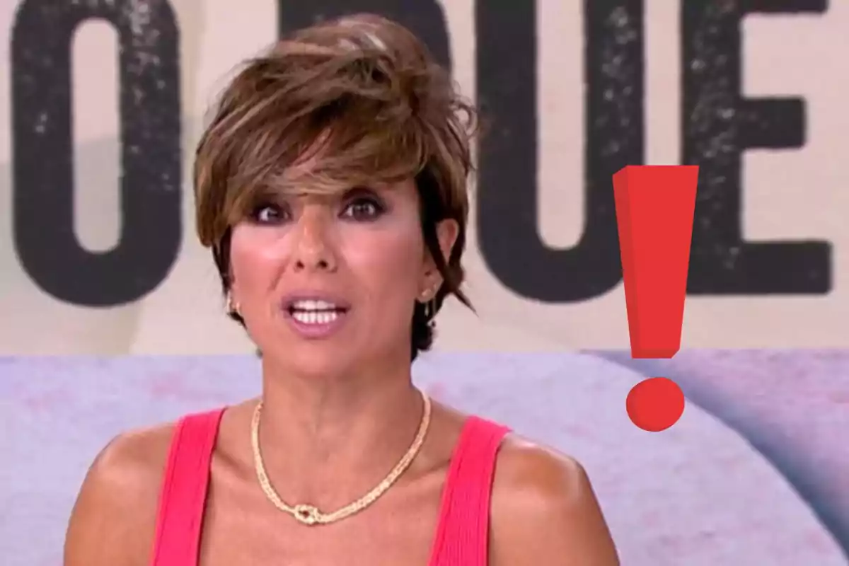 Sonsoles Ónega de cabello corto y castaño con expresión de sorpresa usando un vestido rosa y un collar dorado junto a un gran signo de exclamación rojo
