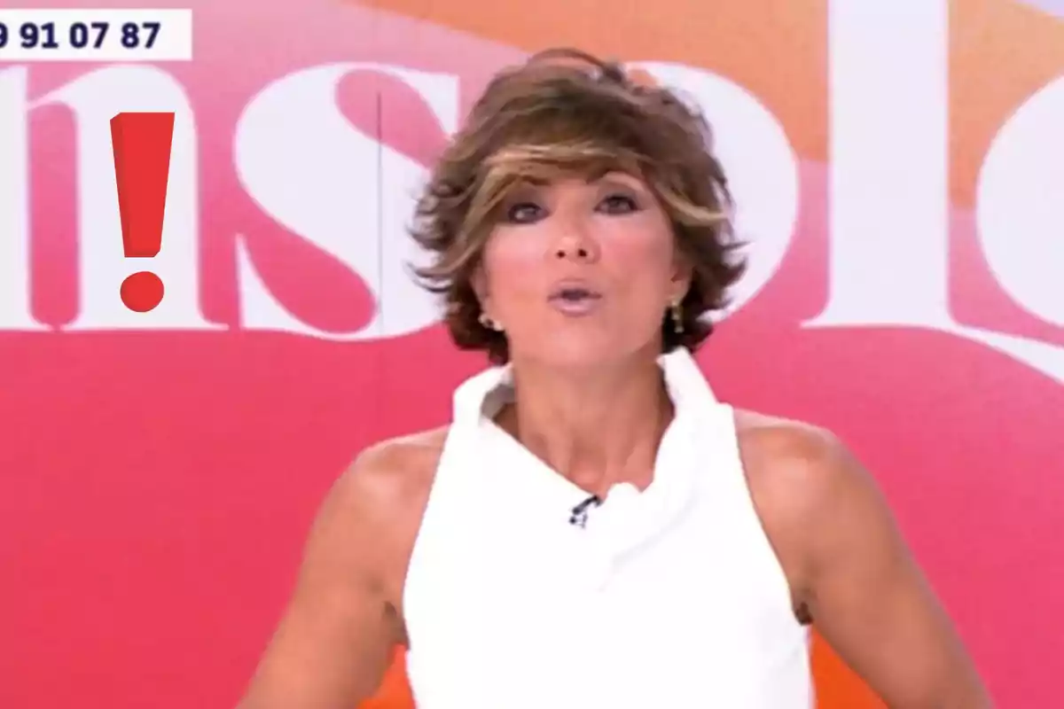 Presentadora de televisió amb expressió de sorpresa en un plató colorit i un signe d’exclamació vermell al seu costat