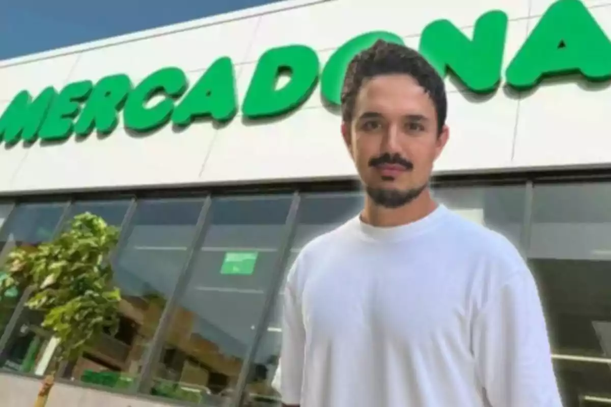 Hombre con camiseta blanca de pie frente a una tienda Mercadona