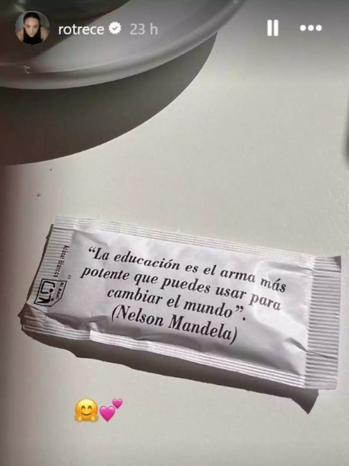 Sobre una taula blanca hi ha un sobre de sucre amb una frase de Nelson Mandela sobre l’educació i al fons es veu part d’un plat blanc. Sobre una taula blanca hi ha un sobre de sucre amb una frase de Nelson Mandela sobre l’educació i al fons es veu part d’un plat blanc.