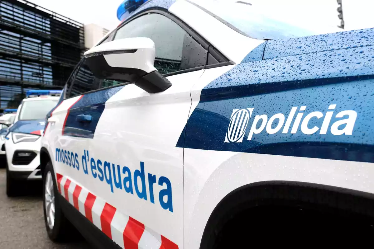 Un cotxe de policia dels Mossos d'Esquadra amb gotes de pluja a la carrosseria.