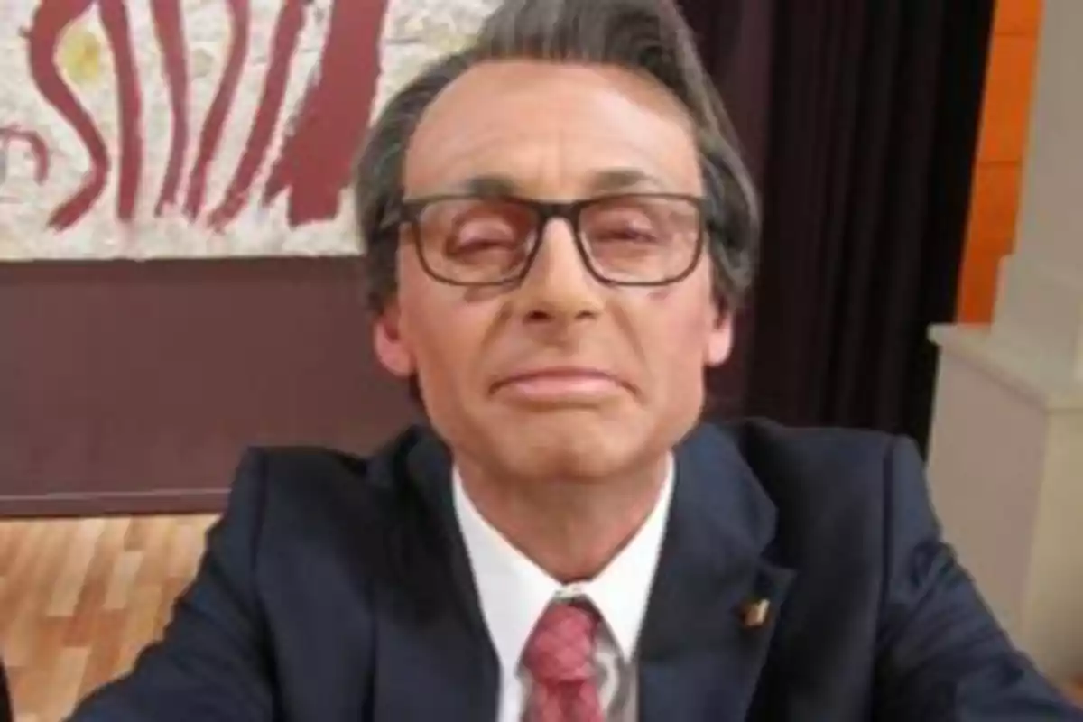 Un home amb ulleres i vestit fosc, amb una corbata vermella, mira directament a la càmera amb una expressió seriosa. Un home amb ulleres i vestit fosc, amb una corbata vermella, mira directament a la càmera amb una expressió seriosa.