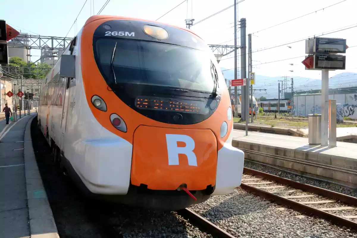 Un tren de rodalies en una estació amb la lletra "R" al front.