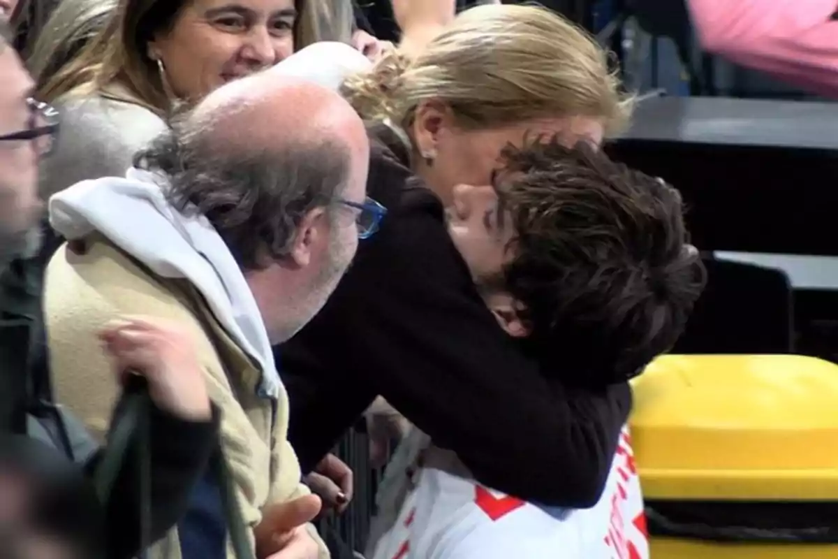 A group of people smile as Infanta Cristina hugs Pablo Urdangarin after the handball match between Granollers and Torrelavega A group of people smile as Infanta Cristina hugs Pablo Urdangarin after the handball match between Granollers and Torrelavega
