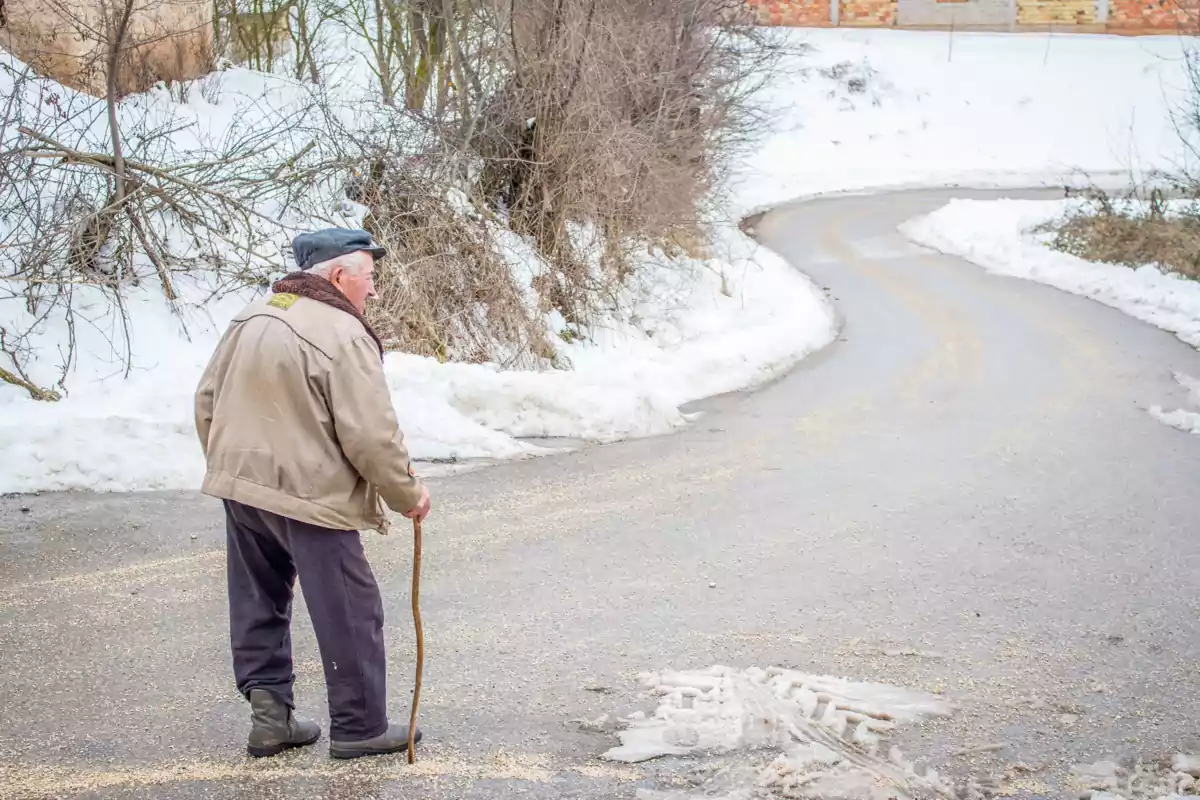 Persona gran passejant per la neu