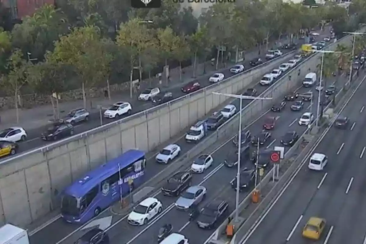 Tráfico denso en una avenida de Barcelona con varios carriles llenos de coches y un autobús azul.