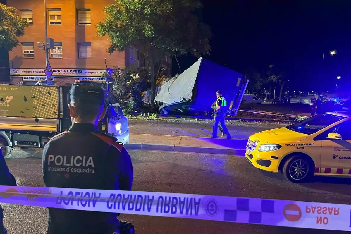 Accidente de camión en la vía pública con presencia de la policía y servicios de emergencia.