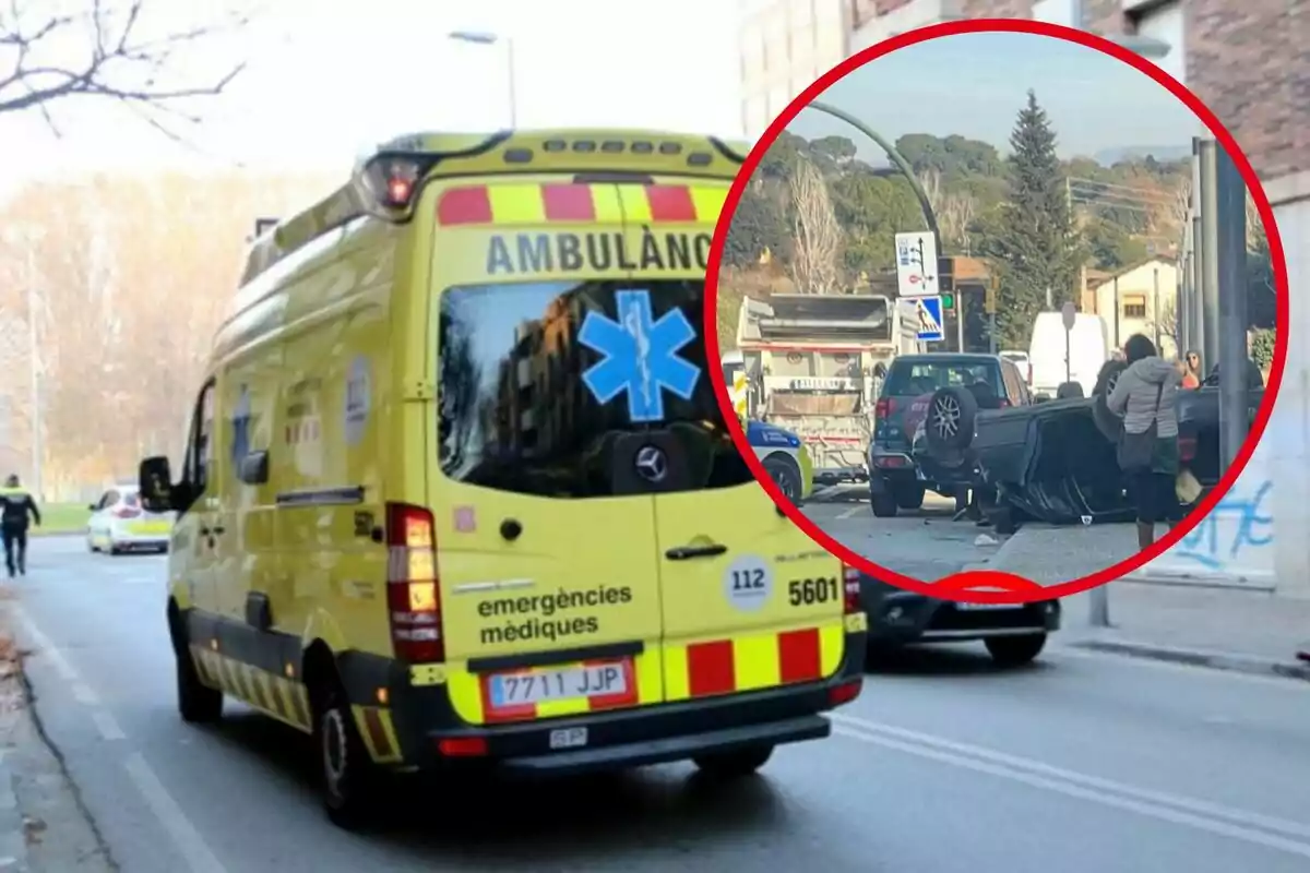 Una ambulancia amarilla se dirige a un accidente de tráfico donde un coche está volcado en la calle.