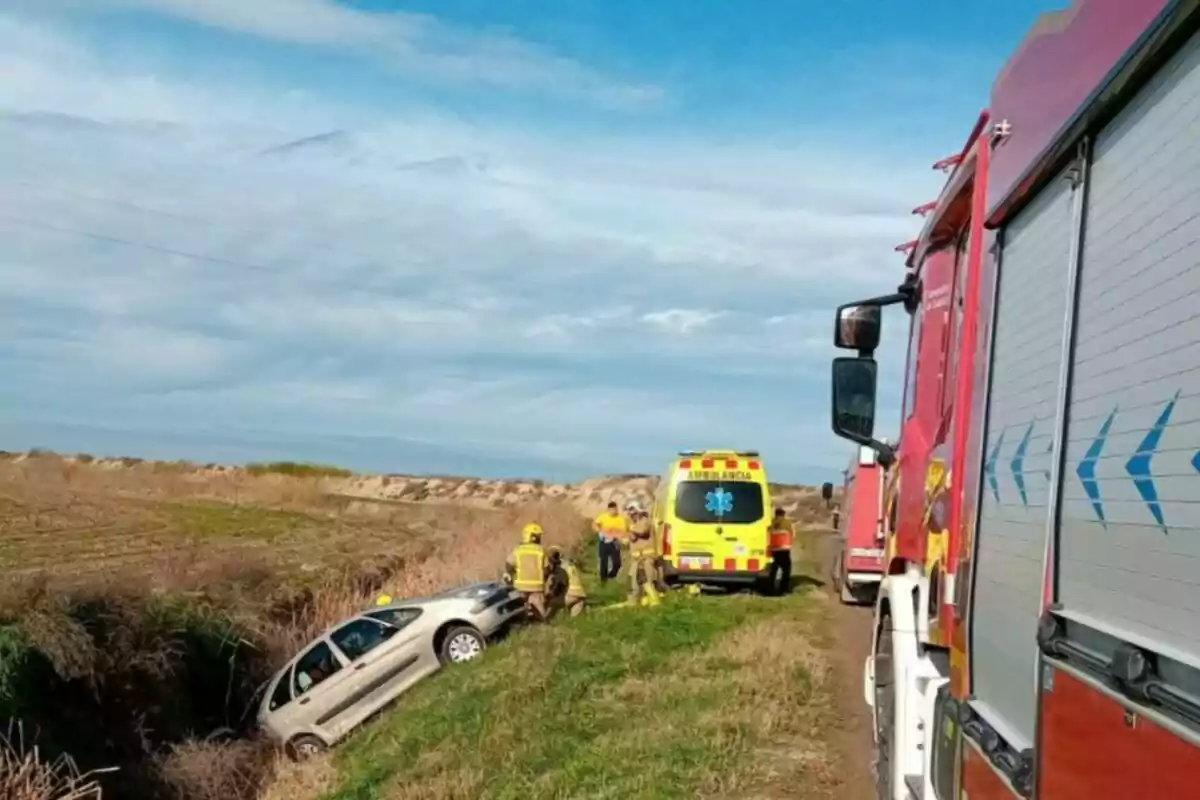 Un cotxe ha sortit de la carretera i ha caigut en una rasa mentre els bombers i una ambulància són al lloc per atendre la situació.