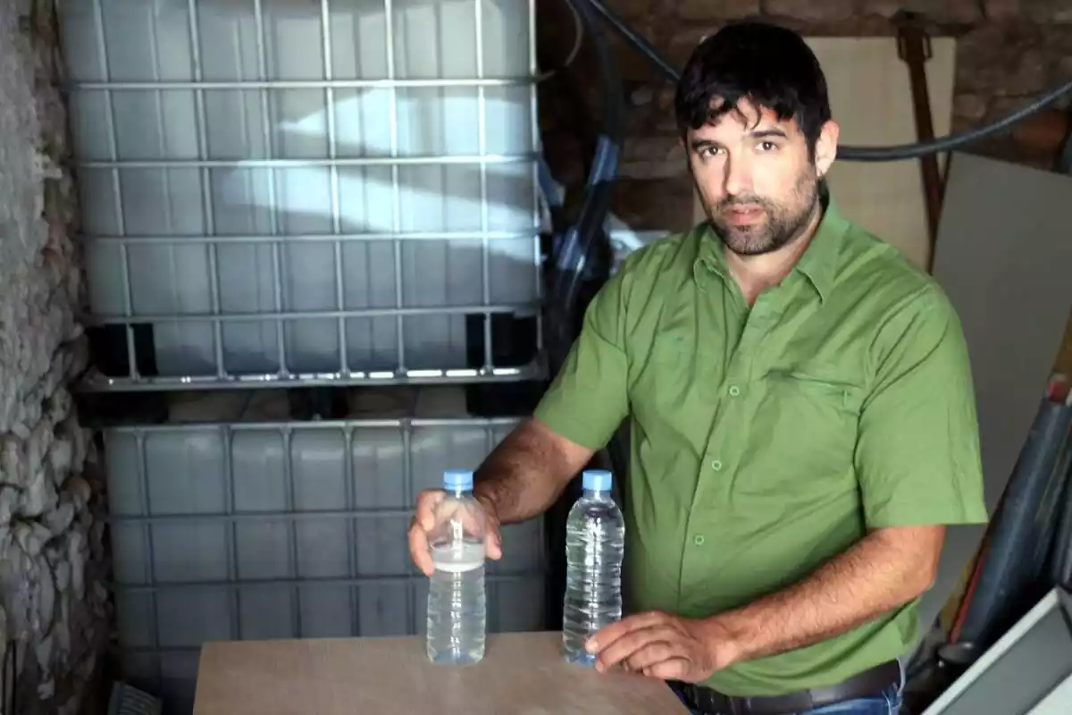 Jordi Arnau amb dues ampolles d'aigua sobre una taula