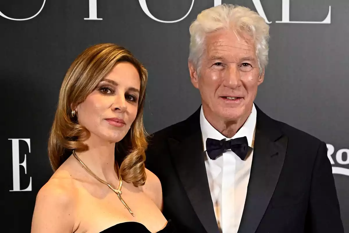 Alejandra Silva i Richard Gere elegantment vestida posen en un esdeveniment formal amb fons fosc. Alejandra Silva i Richard Gere elegantment vestida posen en un esdeveniment formal amb fons fosc.