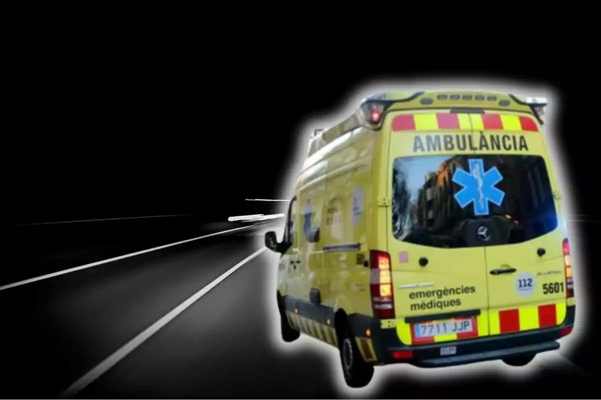 Una ambulància groga circula ràpidament per una carretera fosca.