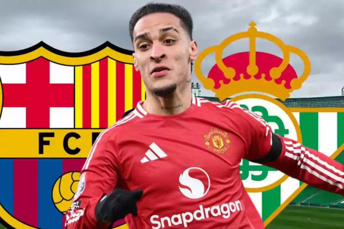 Futbolista amb l’uniforme del Manchester United davant dels escuts del FC Barcelona i del Real Betis