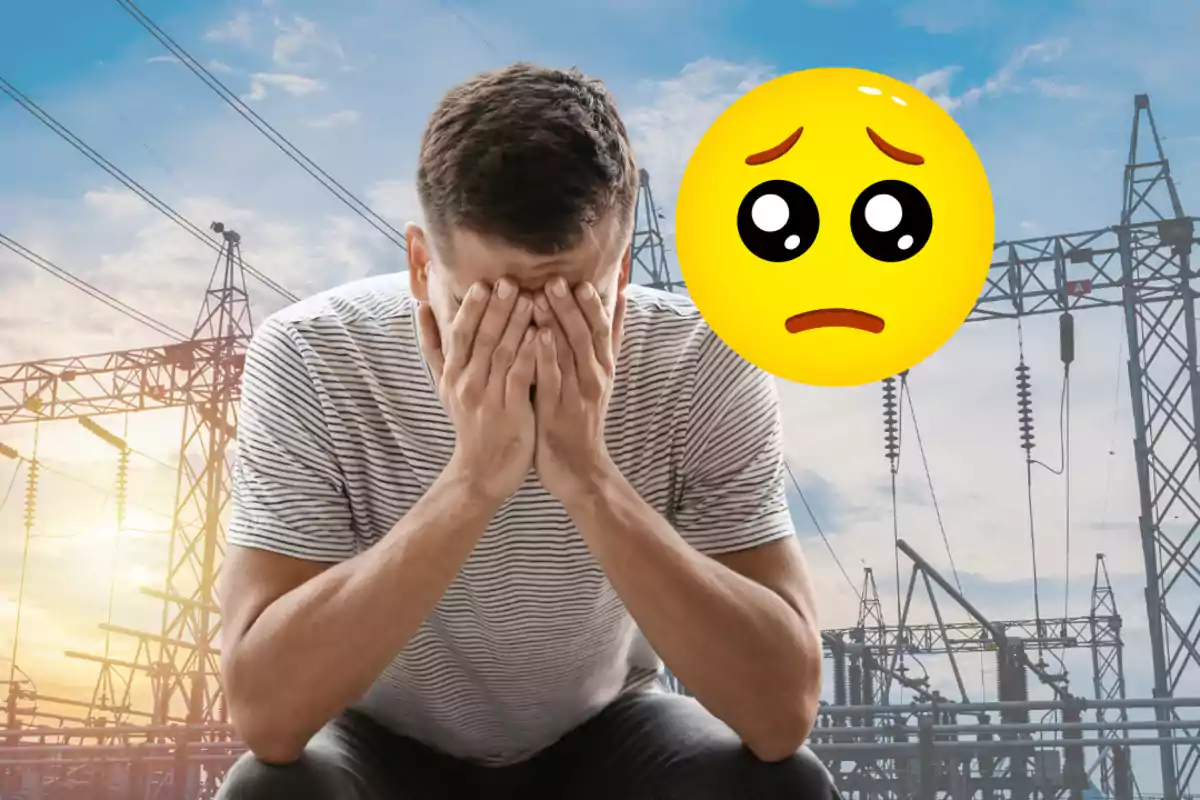 Un home amb les mans a la cara sembla preocupat mentre està davant d'una estructura elèctrica amb un emoji trist flotant al seu costat.
