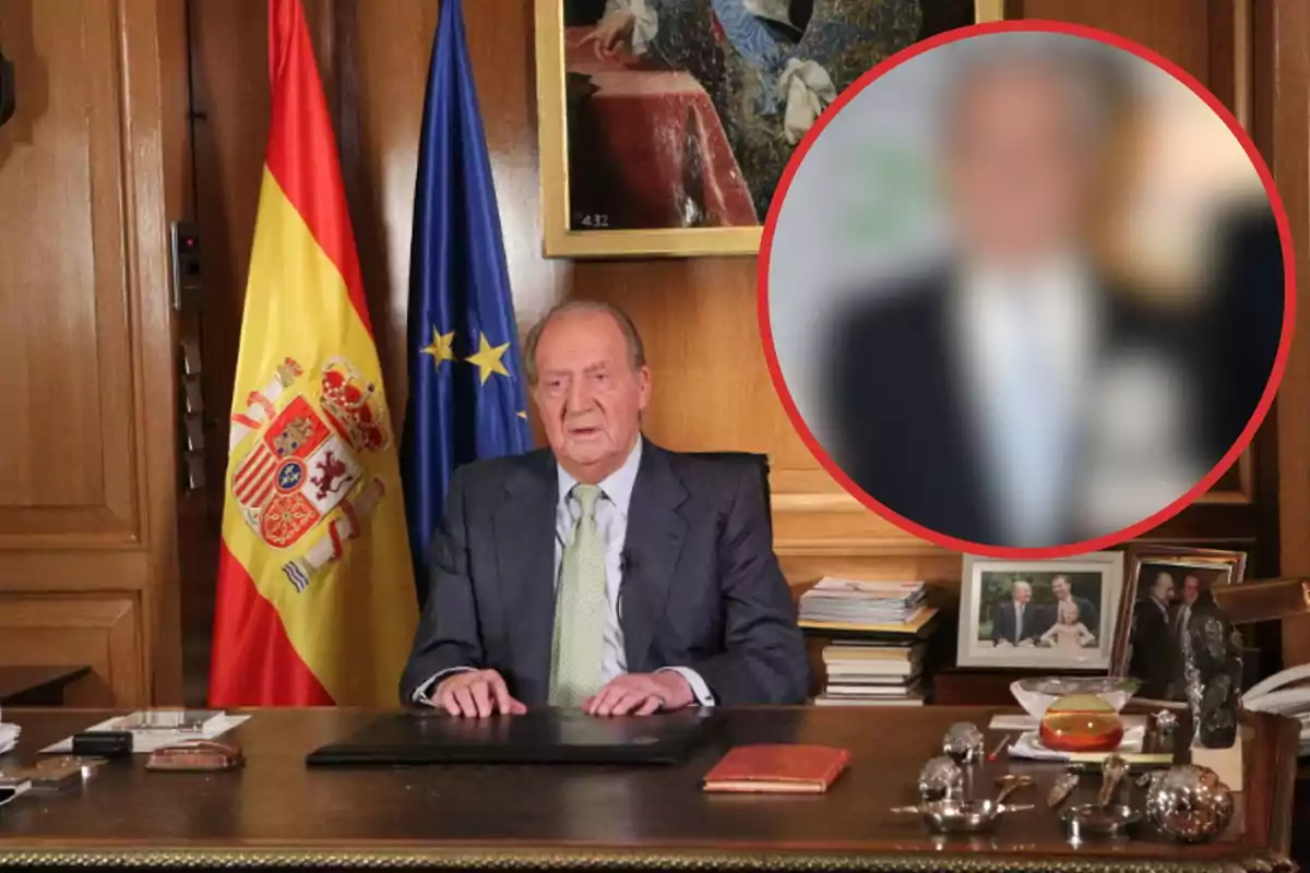 Un hombre mayor sentado en un escritorio con una bandera de España y una bandera de la Unión Europea detrás de él, con una imagen borrosa de otra persona en un círculo rojo a la derecha.