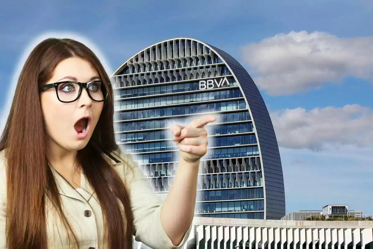 Mujer sorprendida señalando un edificio moderno con el logo de BBVA.