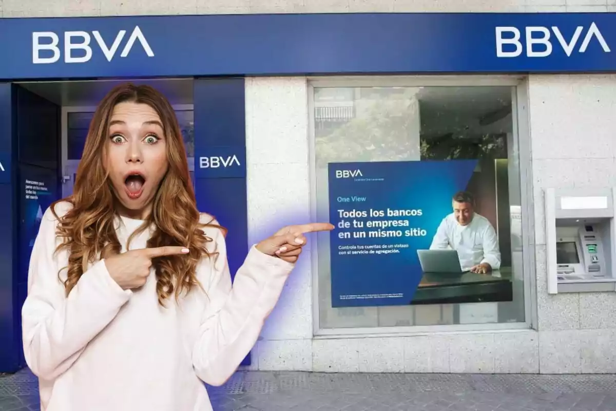 Una dona sorpresa assenyala un cartell a la façana d?un banc BBVA.