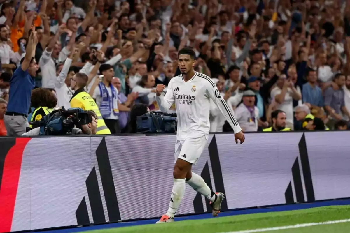 Un jugador de futbol del Reial Madrid celebra un gol mentre la multitud a les grades el vitorea.