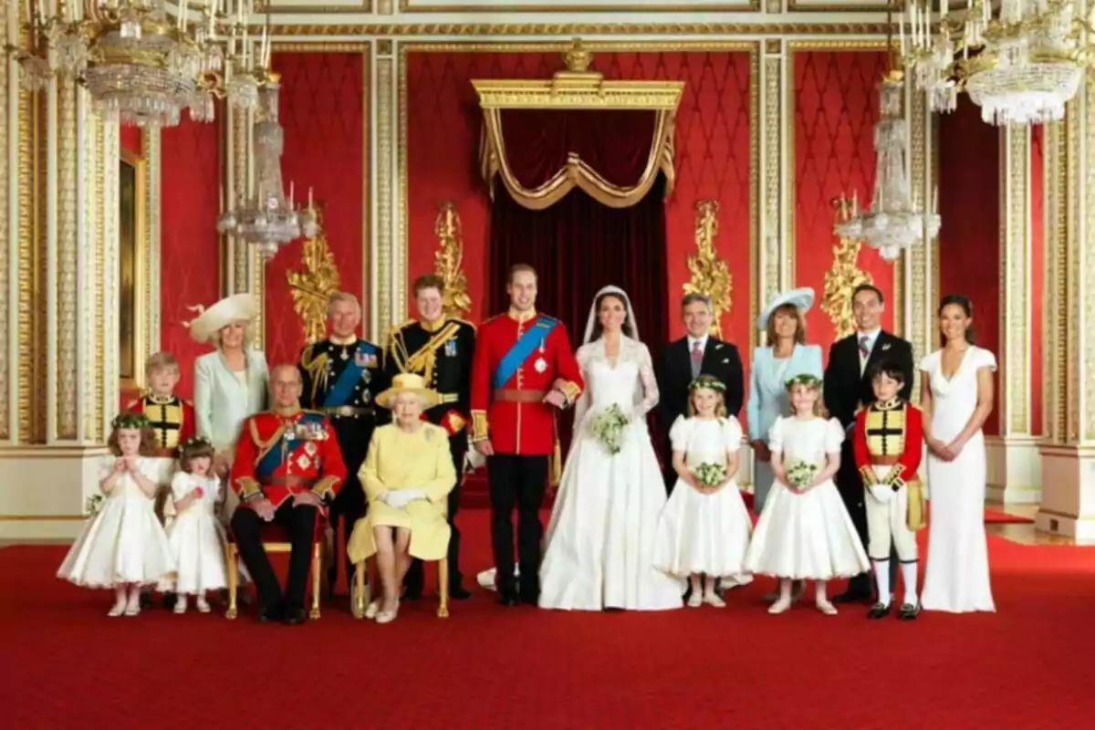 Un grup de persones elegantment vestides posant en una sala decorada amb parets vermelles i detalls daurats. Un grup de persones elegantment vestides posant en una sala decorada amb parets vermelles i detalls daurats.