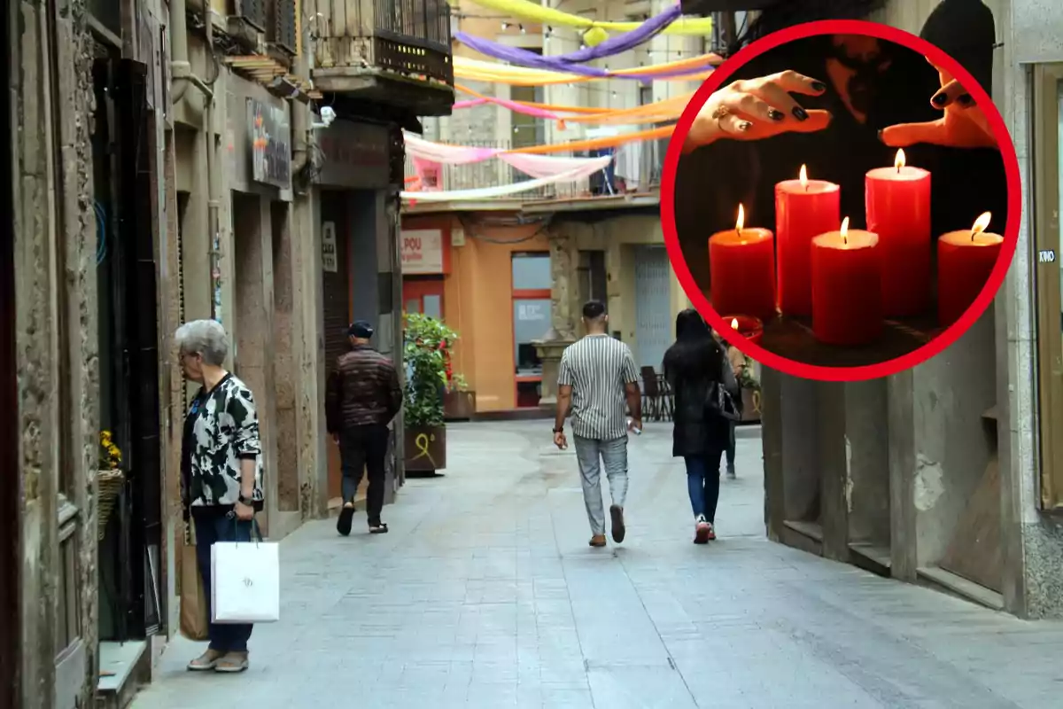 Un carrer estret amb persones caminant i una imatge superposada d'espelmes vermelles enceses.