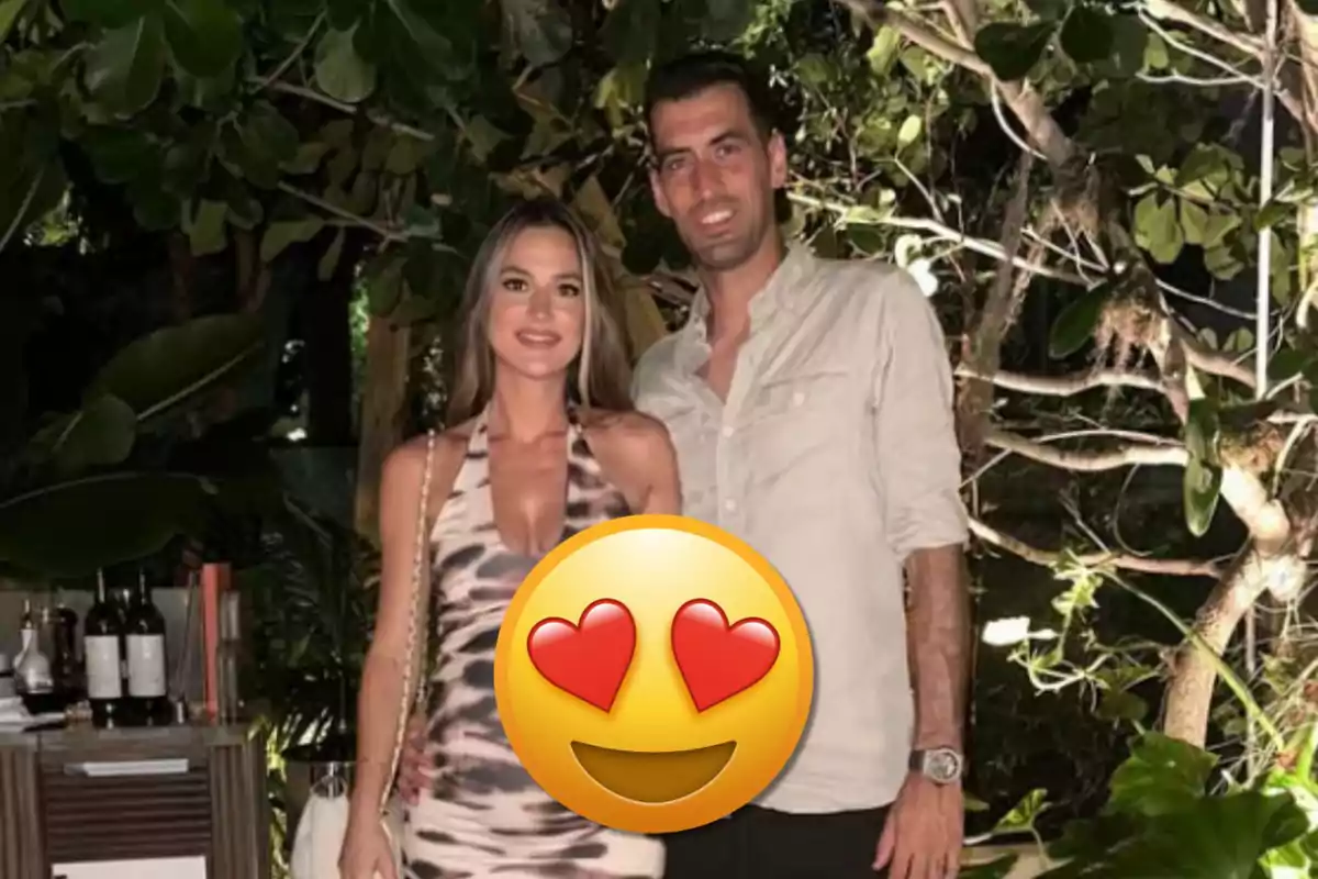 Una pareja posando juntos en un entorno natural con un emoji de cara con corazones superpuesto en el centro de la imagen.