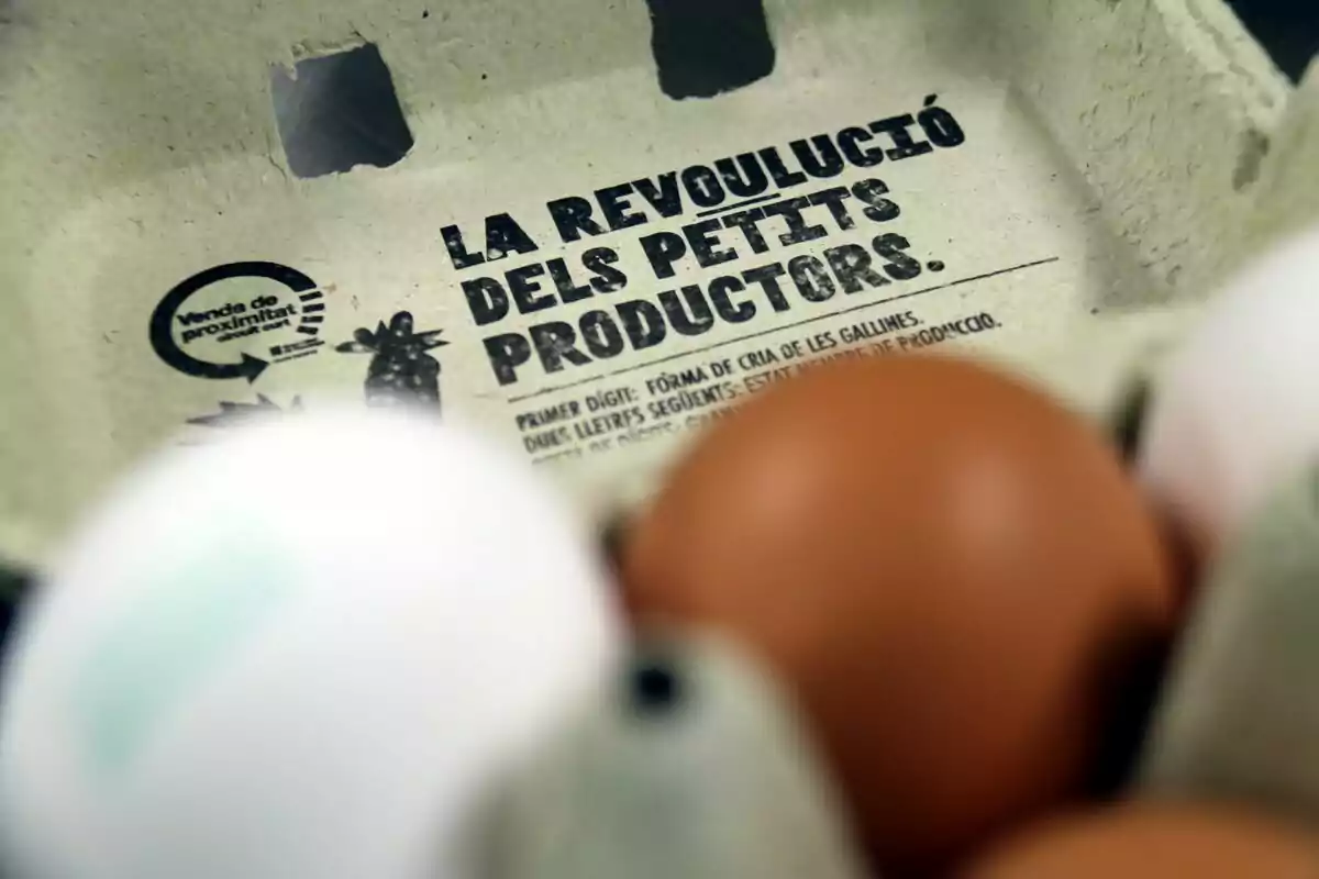 Cartró d'ous amb la inscripció "La Revolució dels Petits Productors" i el logotip de "Venda de Proximitat".