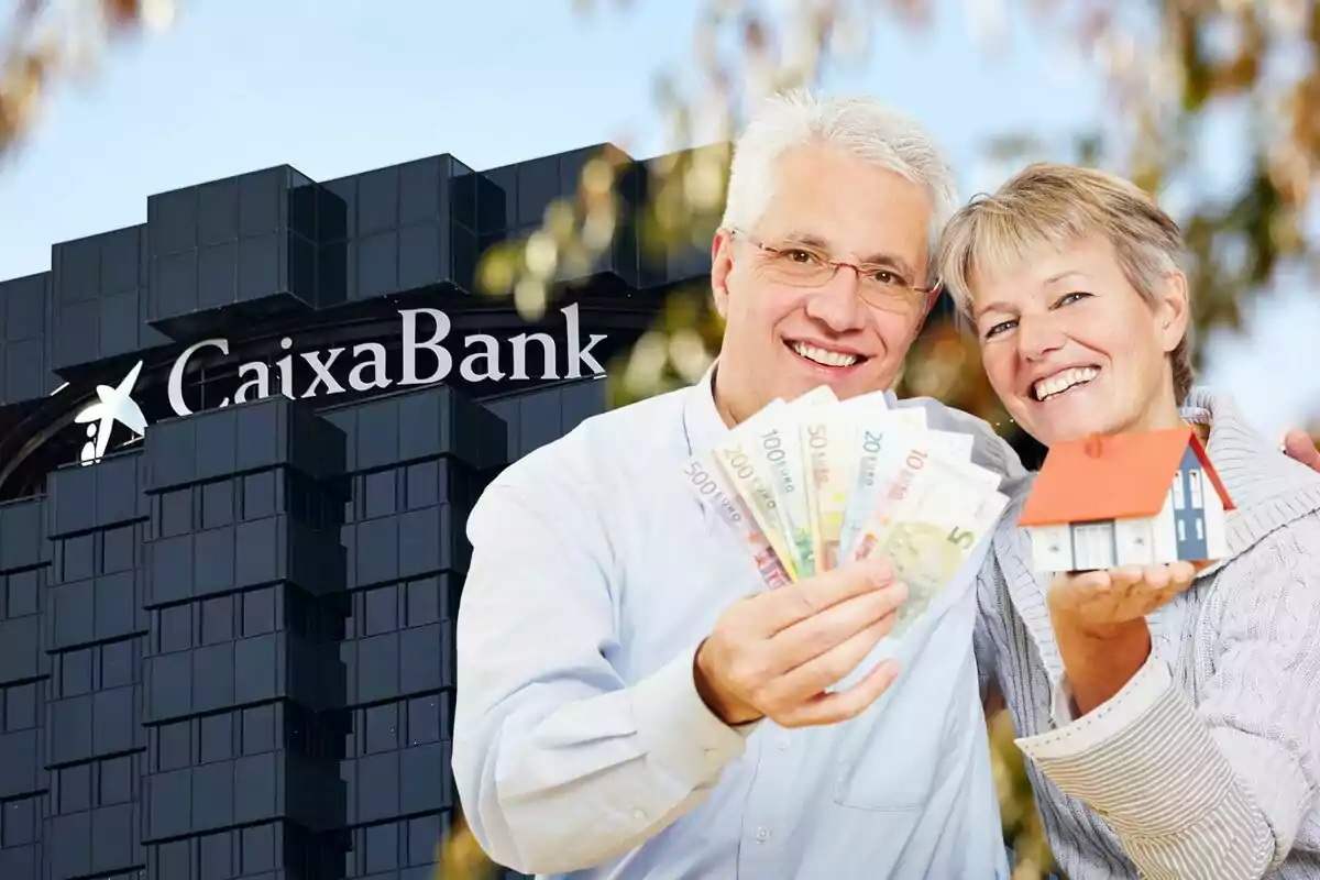 Pareja sonriente sosteniendo billetes de euro y una casa en miniatura frente a un edificio de CaixaBank.