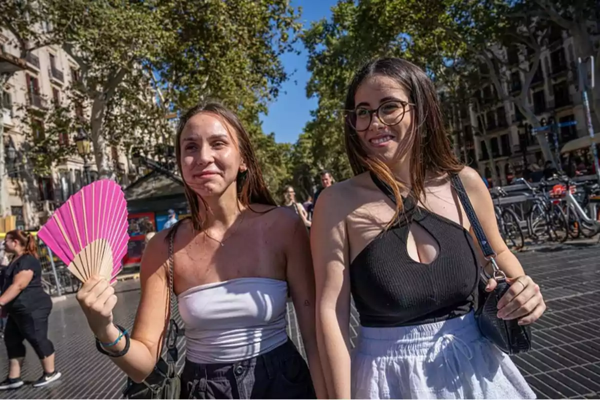 Dos jóvenes paseando por una calurosa Barcelona