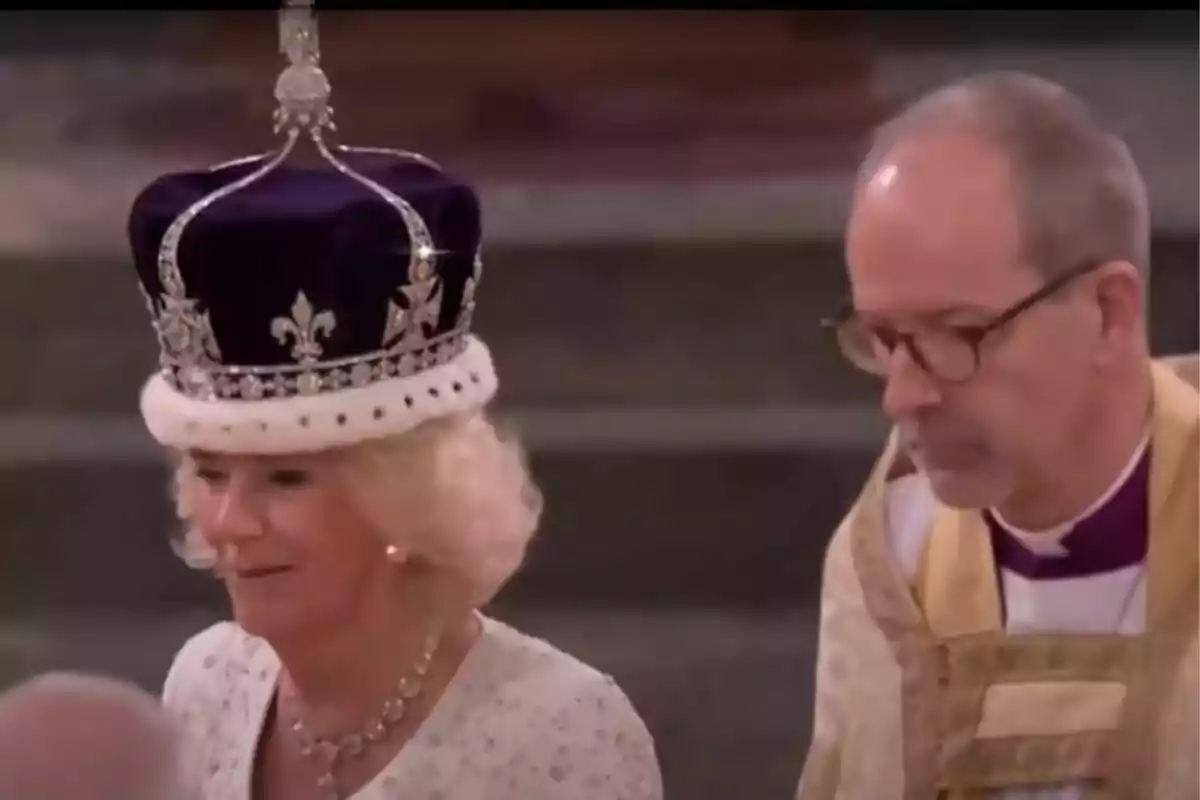 Una mujer con una corona adornada y un hombre con vestimenta ceremonial en un evento formal.