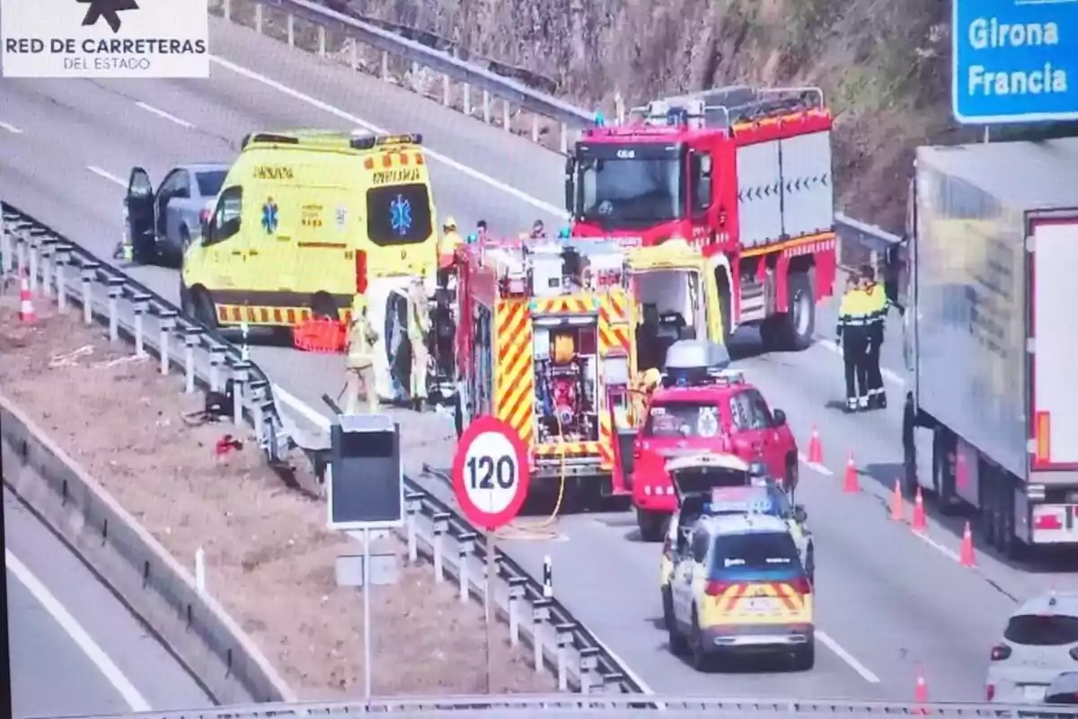 Un accident de trànsit en una autopista amb presència de vehicles d'emergència com ambulàncies i camions de bombers mentre el trànsit està desviat i controlat per la policia.