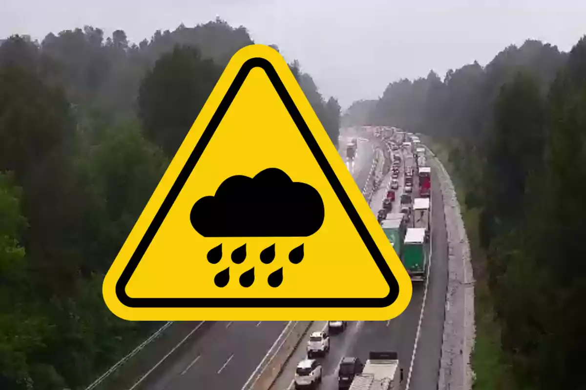 Imatge d'una carretera amb trànsit dens sota la pluja, amb un símbol d'advertència de pluja superposat.