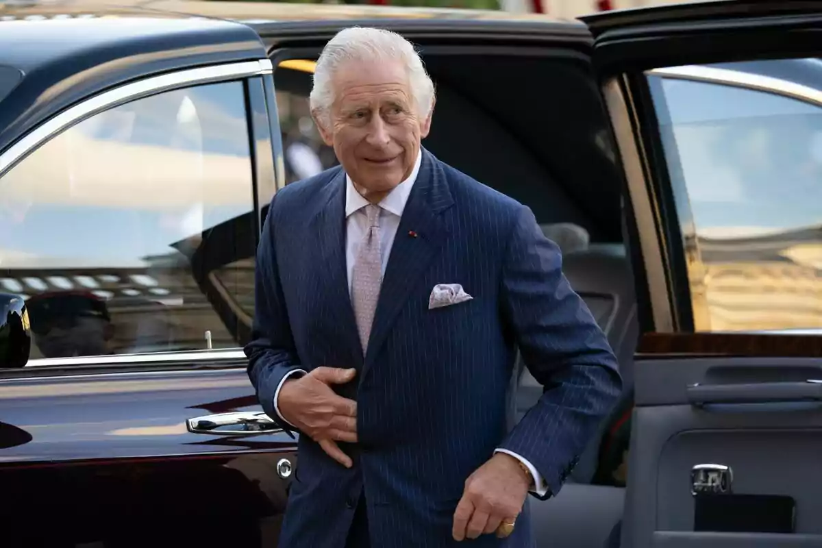 Carles III amb vestit blau de ratlles surt d'un automòbil elegant. Carles III amb vestit blau de ratlles surt d'un automòbil elegant.