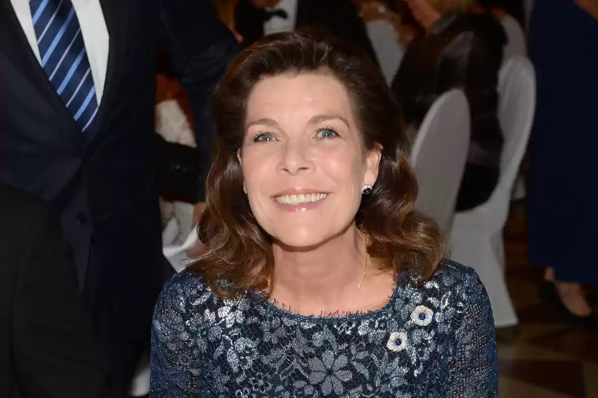 Carolina of Monaco smiling in a blue lace dress at a formal event. Carolina of Monaco smiling in a blue lace dress at a formal event.