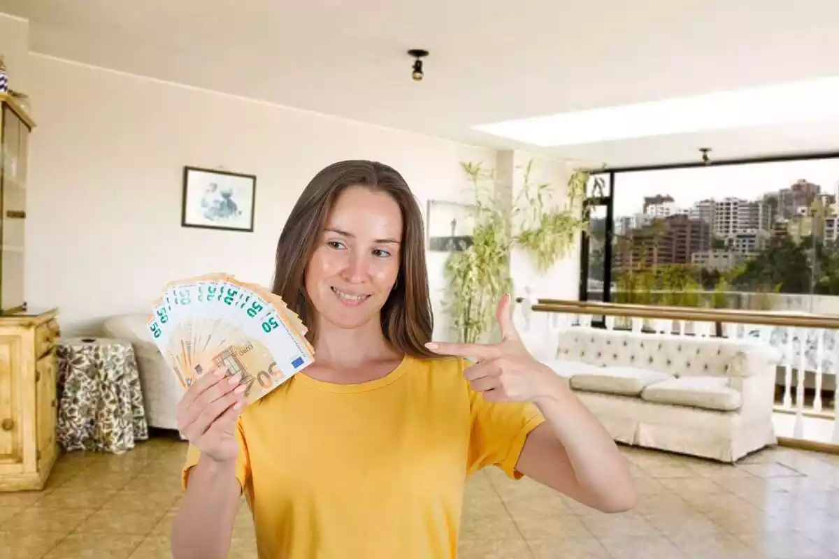 Noia sostenint bitllets de 50 euros dins d'un habitatge