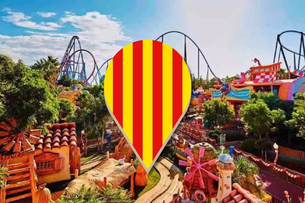 Una imatge d´un parc d´atraccions amb muntanyes russes i diverses atraccions acolorides, amb un marcador d´ubicació amb els colors de la bandera catalana al centre.