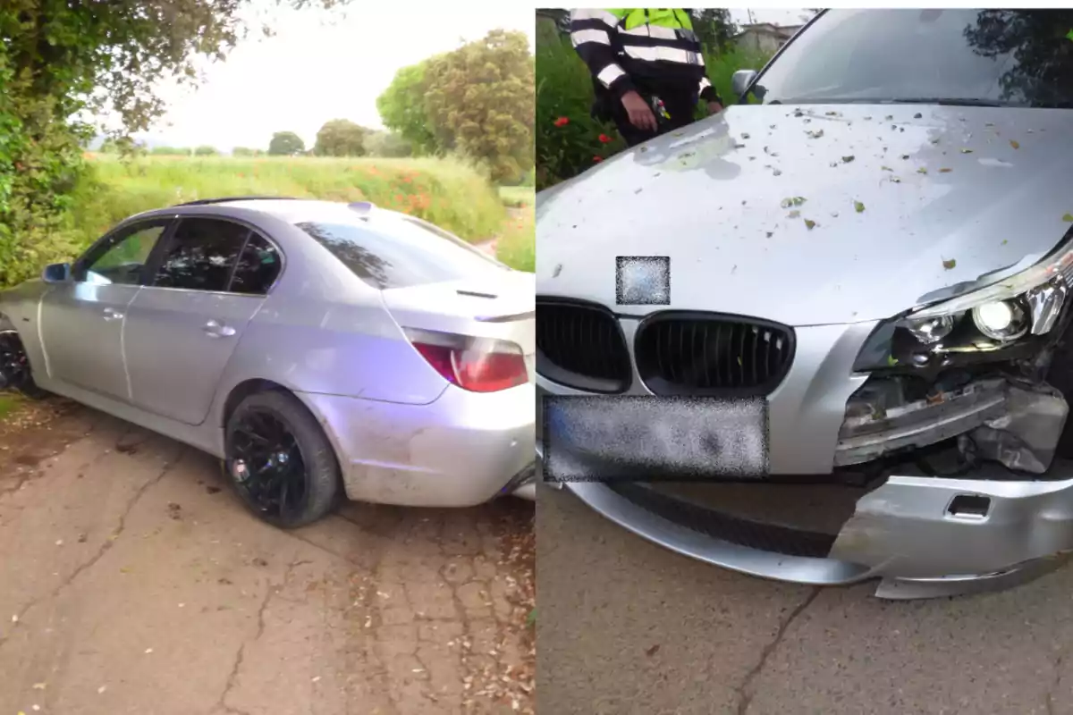 Un coche plateado con daños visibles en la parte delantera y trasera, estacionado en un camino rural con vegetación alrededor.