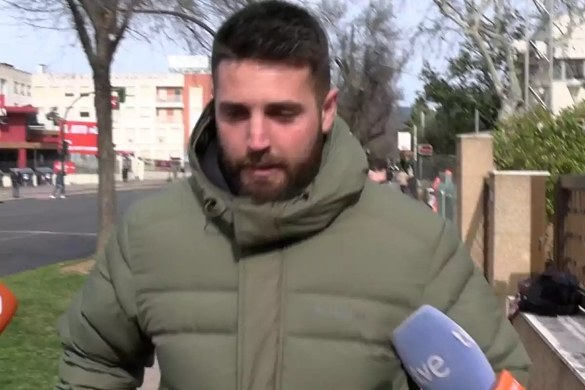 David Rodríguez con chaqueta verde camina por la calle mientras es entrevistado por medios de comunicación. David Rodríguez con chaqueta verde camina por la calle mientras es entrevistado por medios de comunicación.