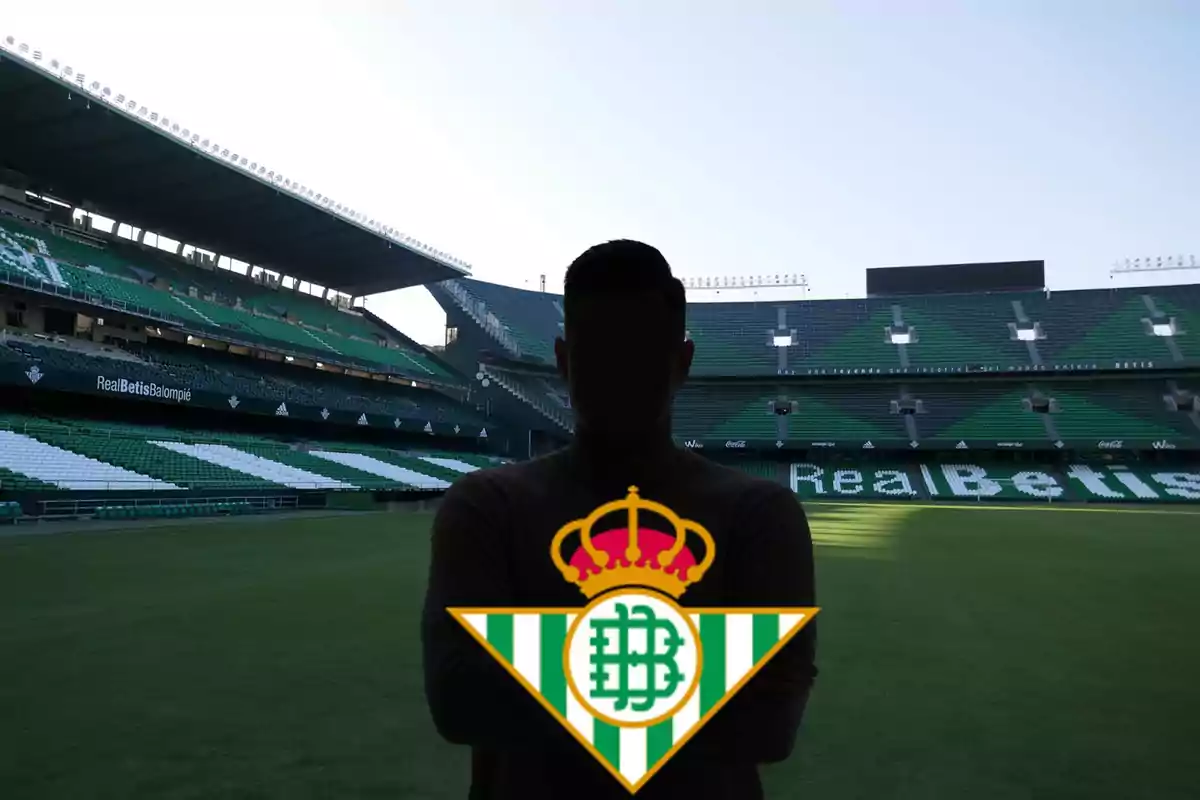 Persona amb el logotip del Real Betis en un estadi de futbol.