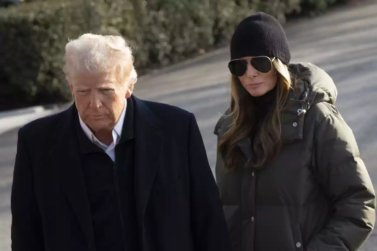 Donald and Melania Trump, wearing sunglasses and black hats, walk together outdoors on a sunny day. Donald and Melania Trump, wearing sunglasses and black hats, walk together outdoors on a sunny day.