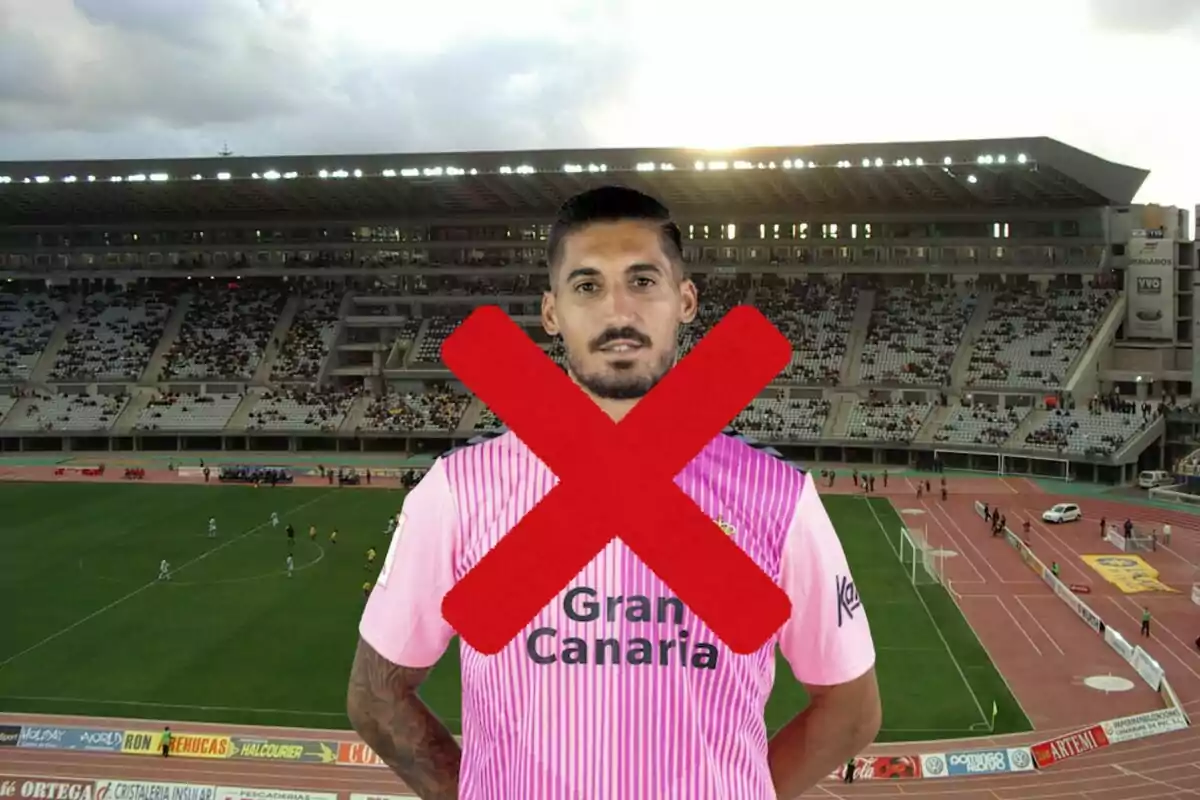 Un jugador de futbol amb una samarreta rosa i una gran X vermella sobre ell, amb un estadi de fons.