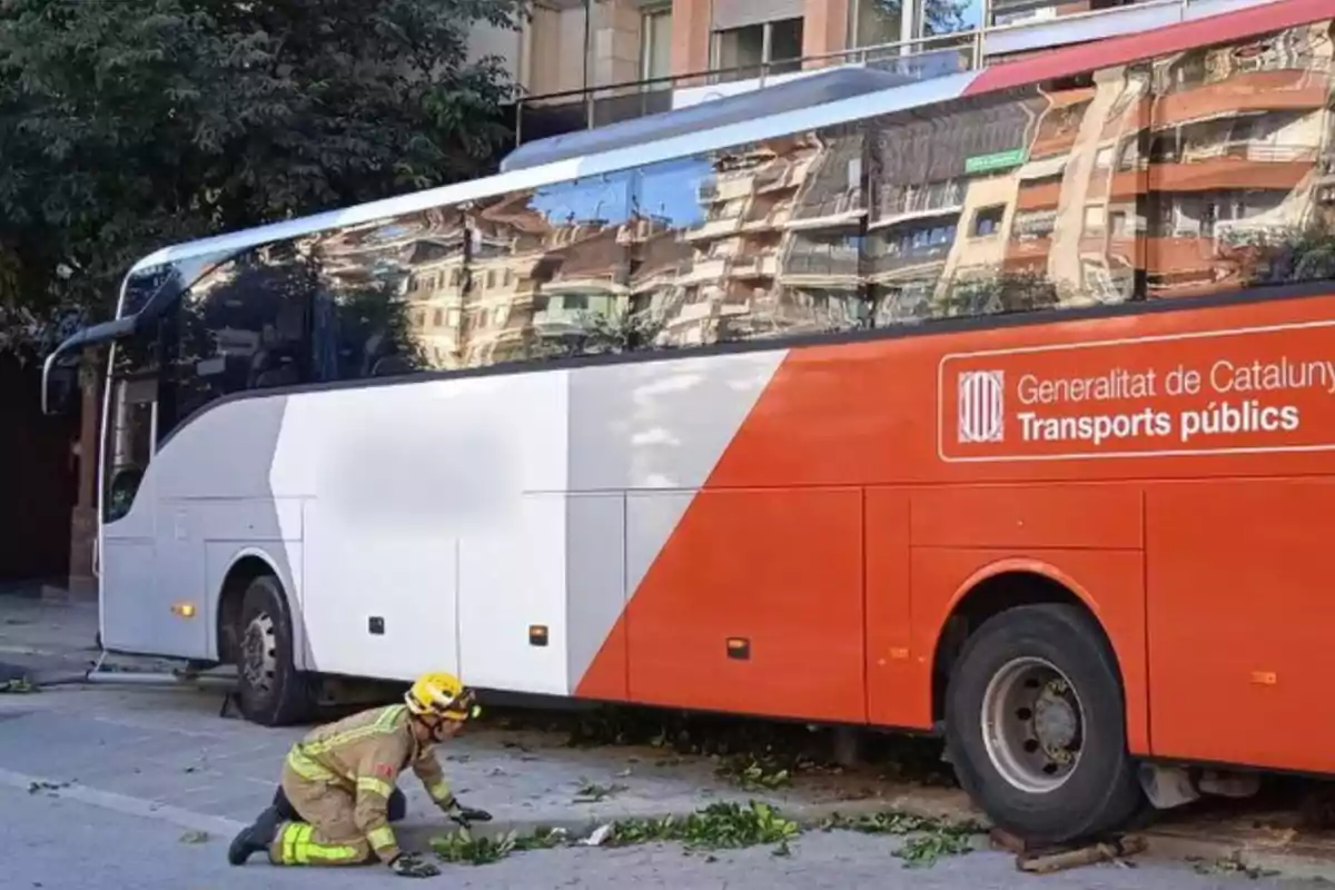 Un bomber treballa a l?escena d?un accident d?autobús en un carrer de la ciutat.