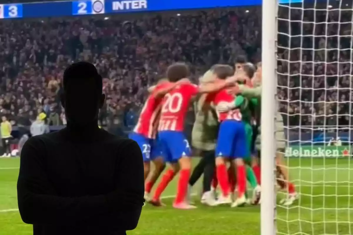 Un grupo de jugadores de fútbol celebrando en el campo mientras una figura oscura con los brazos cruzados se encuentra en primer plano.