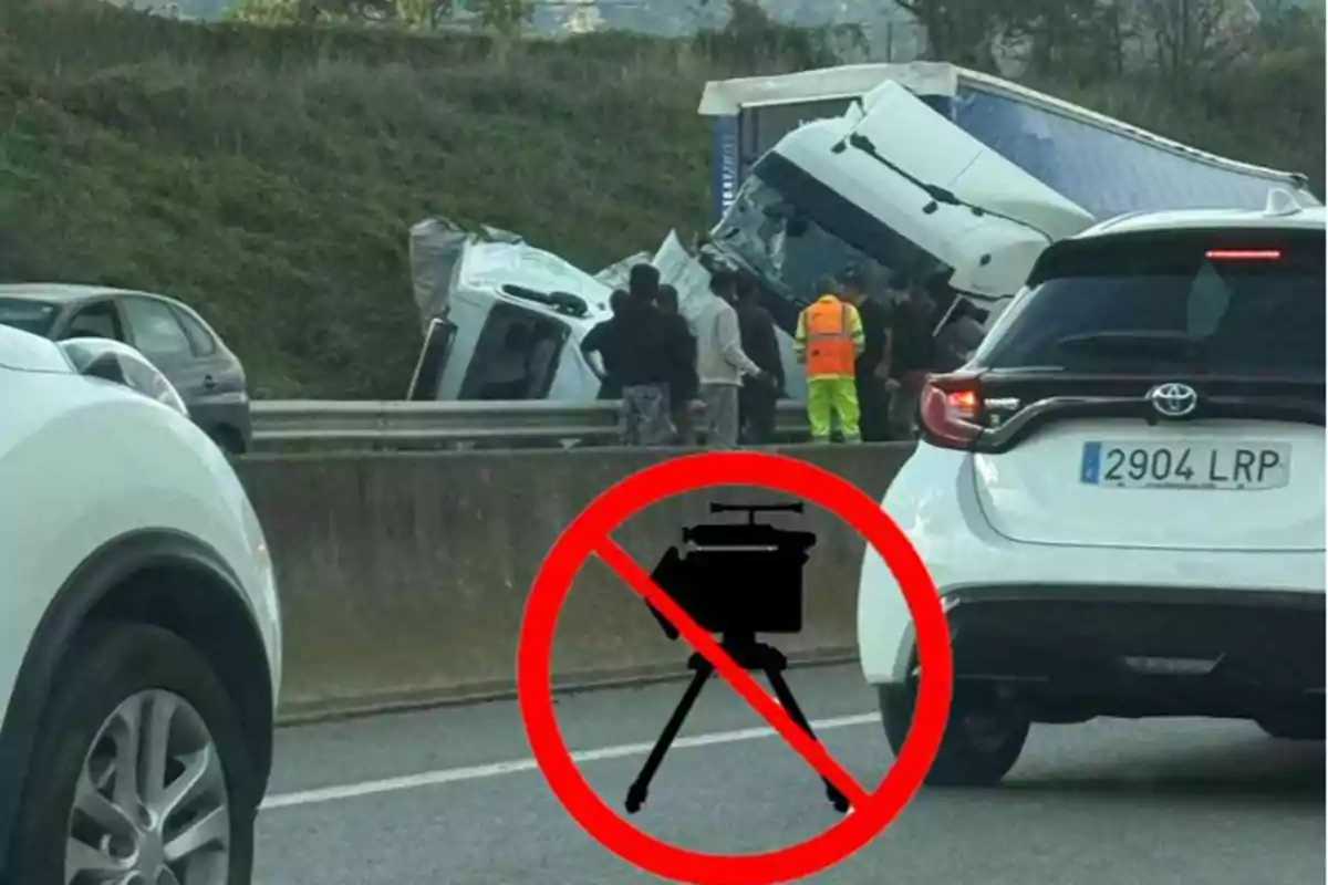 Accidente de tráfico en una carretera con un camión volcado y un símbolo de prohibido radar en primer plano.