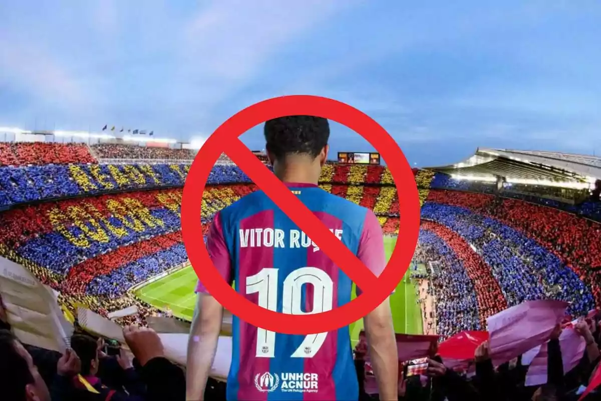 Un jugador de fútbol con la camiseta número 19 y el nombre "Vitor Roque" en la espalda, con un símbolo de prohibición superpuesto, en un estadio lleno de aficionados con colores rojo, azul y amarillo.