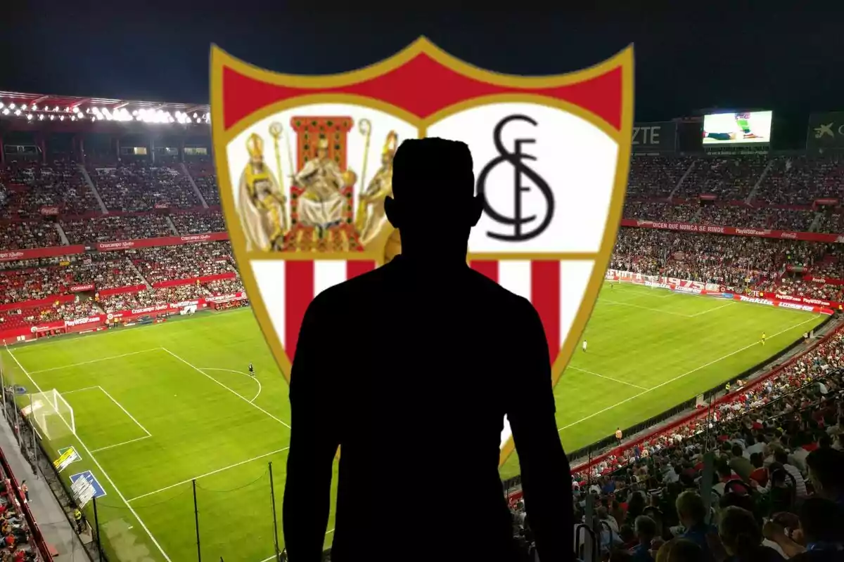 Una silueta d?una persona davant de l?escut del Sevilla FC en un estadi de futbol ple d?espectadors.