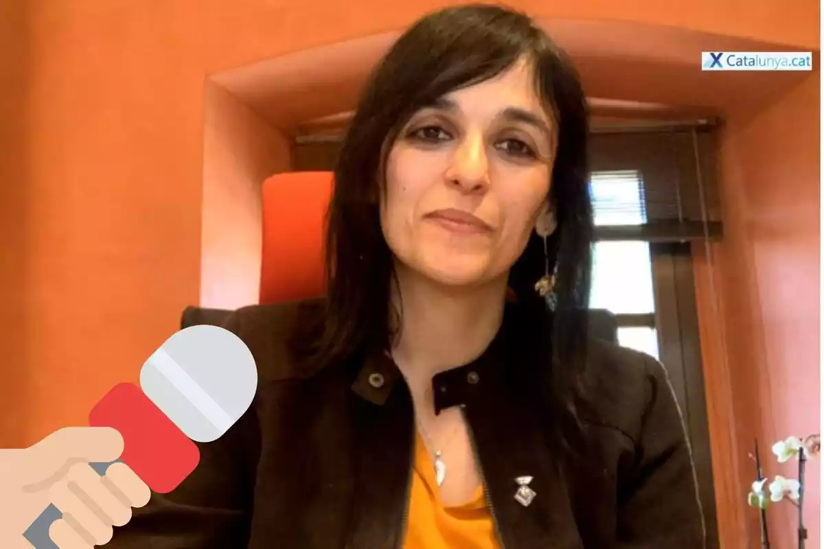 Muntatge amb una imatge de Sílvia Orriols durant l'entrevista concedida a XCatalunya. A la cantonada inferior esquerra, l'emoticona d'una mà sostenint un micròfon